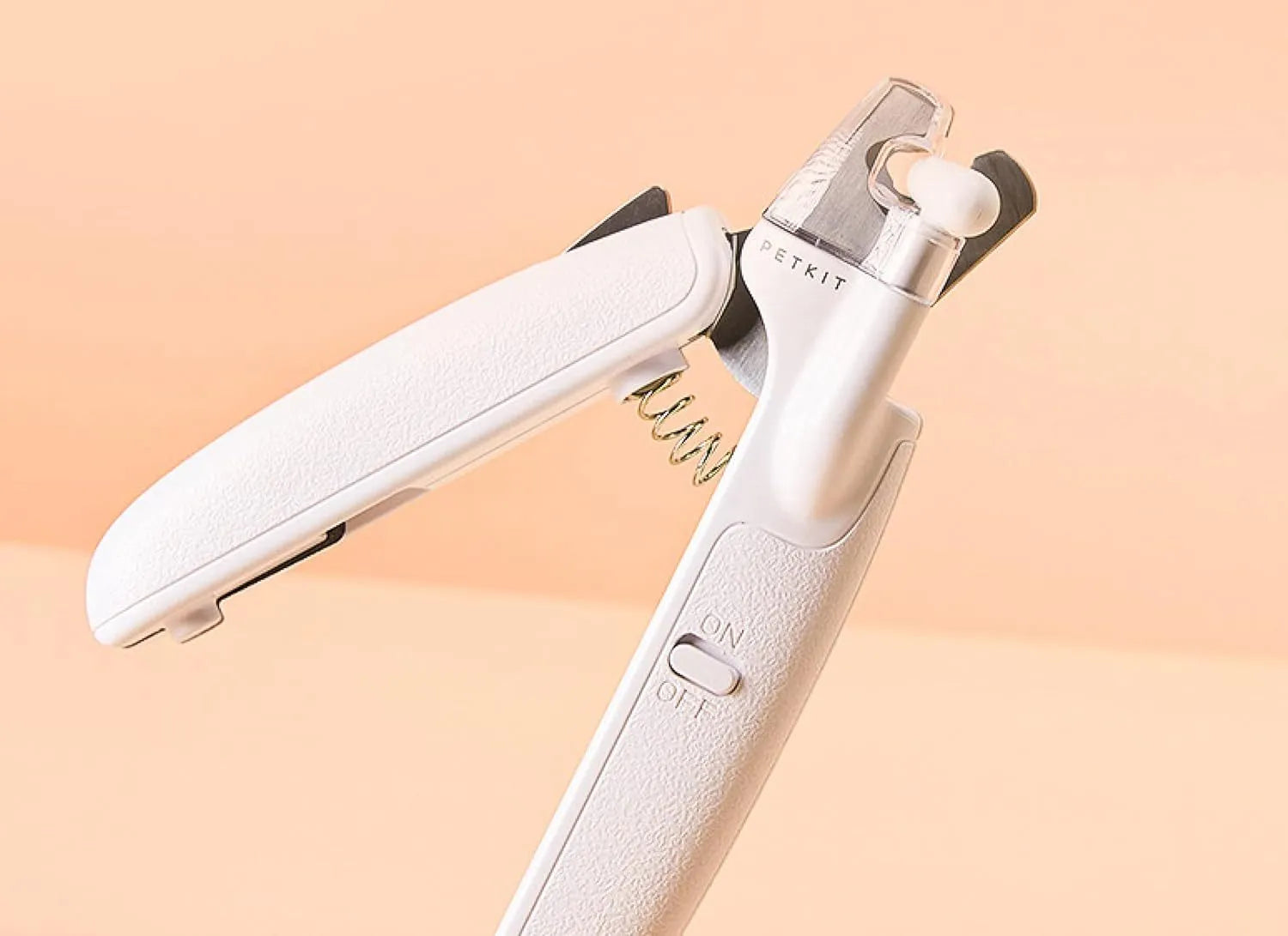White pet nail clippers with LED light, transparent anti-splash guard open, and separate nail file.