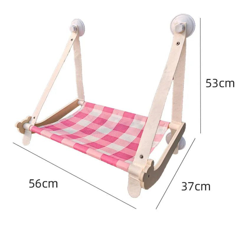 Pink wooden cat hammock bed with suction cups attached to a window