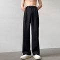 Black wide leg trousers with straight cut and non-iron finish laid flat