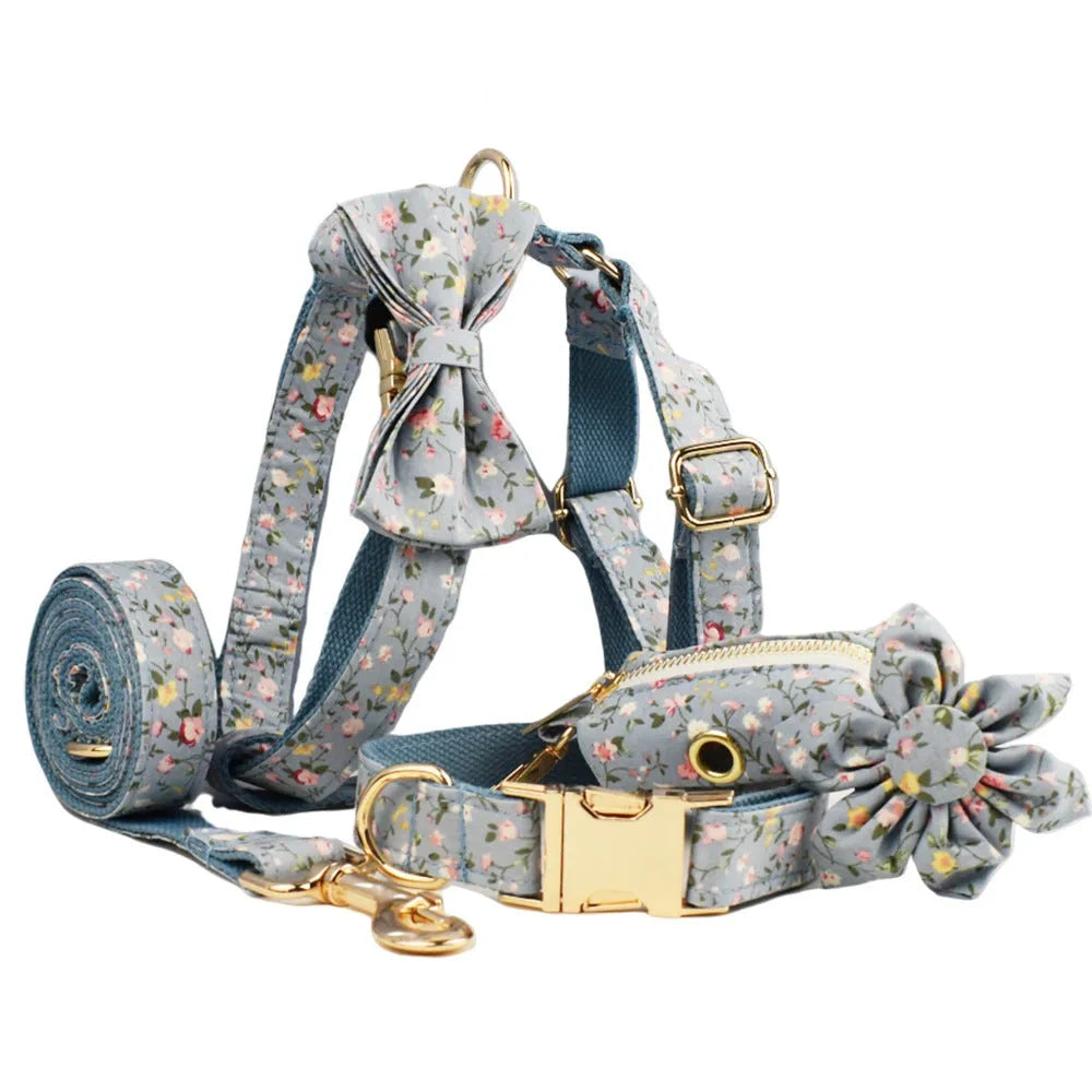 Blue floral pattern dog collar set with matching leash, vest, and accessories on white background