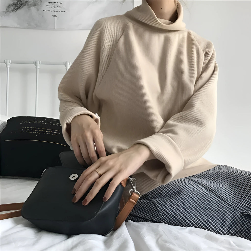 Women's loose fit long sleeve top in solid apricot colour, showing half-high neckline.