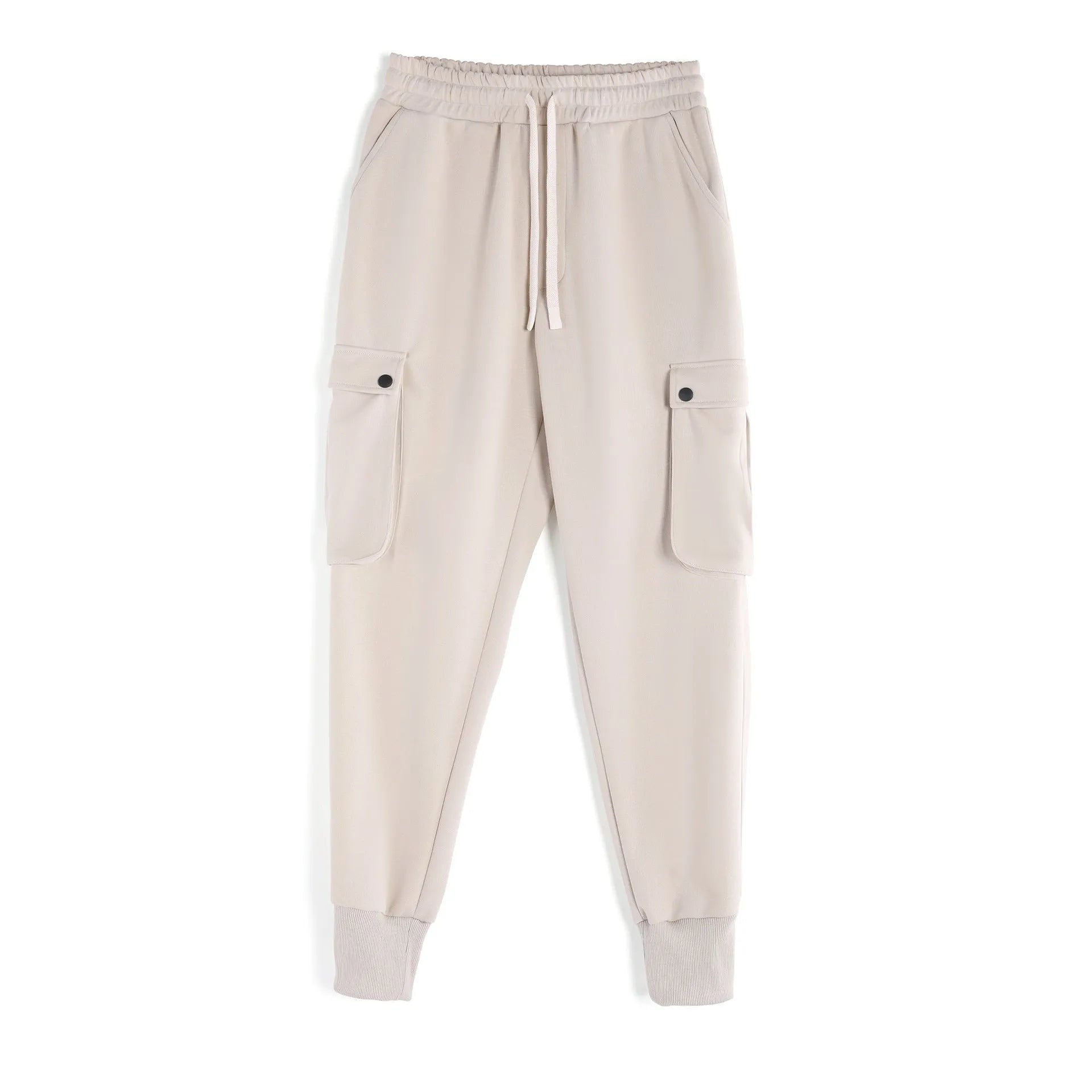 Man wearing loose fit apricot coloured cotton sports trousers with ankle ties and multiple pockets.