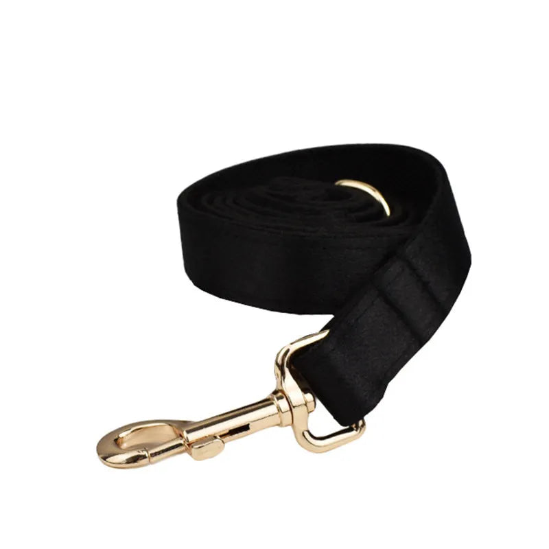 A complete cloth dog accessory set showing a collar, leash, chest strap, vest, and decorative bow in matching colours.