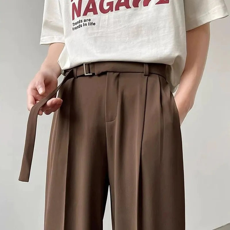 Black wide leg trousers with straight cut and non-iron finish laid flat
