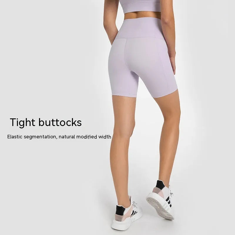 Women's tight-fit cotton blend sports shorts in light purple lotus colour, showing short fifth pants length.