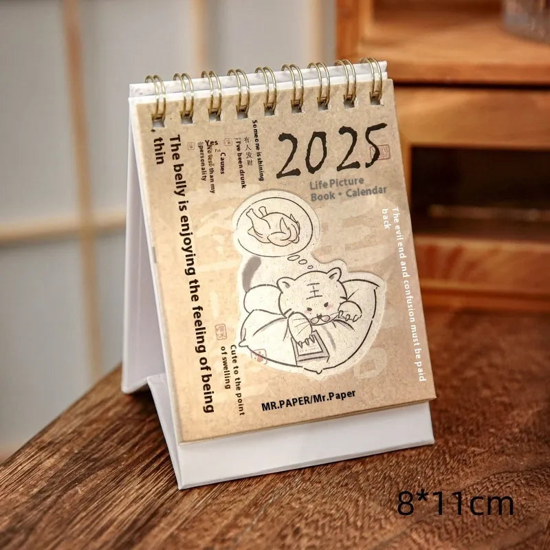 Set of four different 2025 mini paper desk calendars with simple modern designs on a desk.