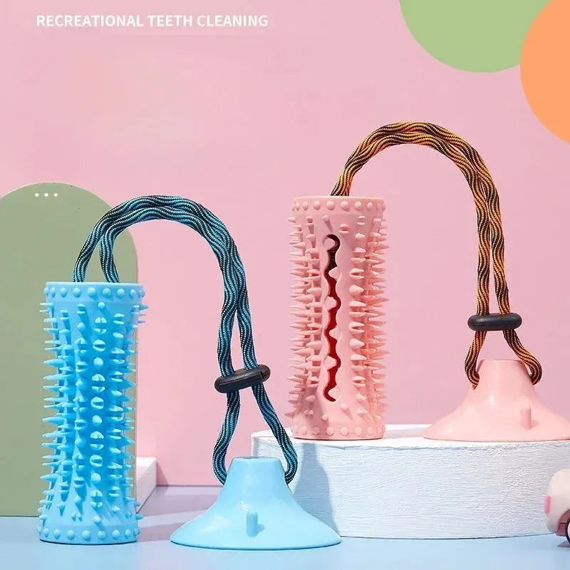 Blue and pink dog chew ball toy with suction cup and food dispenser on tiled floor
