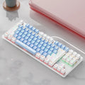 Red and black 87-key compact mechanical keyboard with green axis switches on a desk, shown with blue mixed light backlight