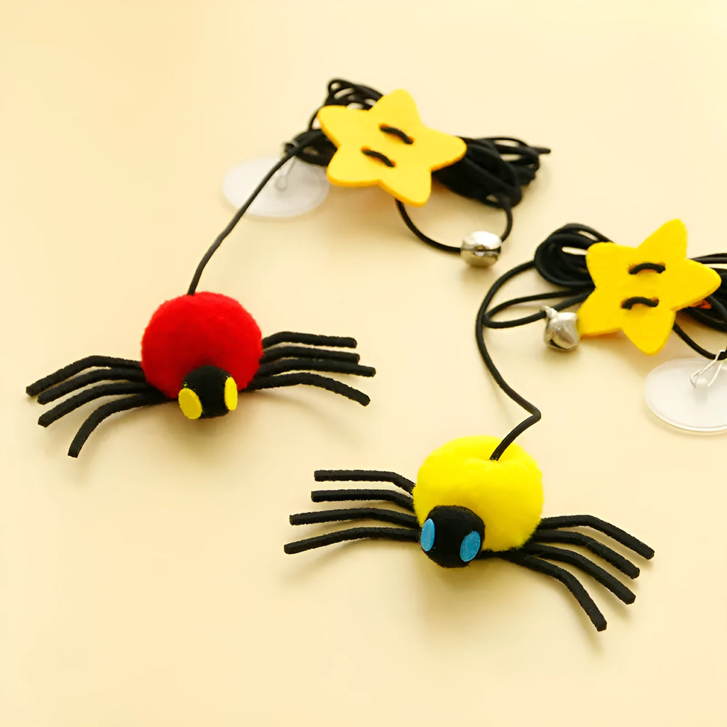 Red cat toy hanging from door with elastic rope, feather stick, bell, and spider decoration